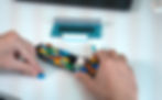 Close-up of hands assembling a colorful LEGO® freight ship on a white desk, highlighting meticulous design, precision, thoughtfulness, mindfulness and creativity in LEGO® building.