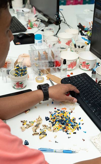 lego pieces lying around before a man working on desktop computer