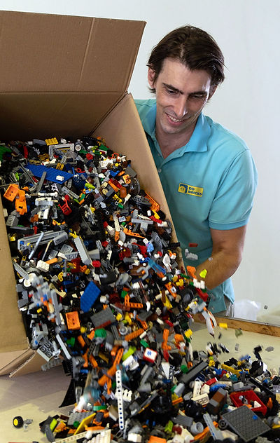 Colorful LEGO bricks falling out of a box onto a white surface